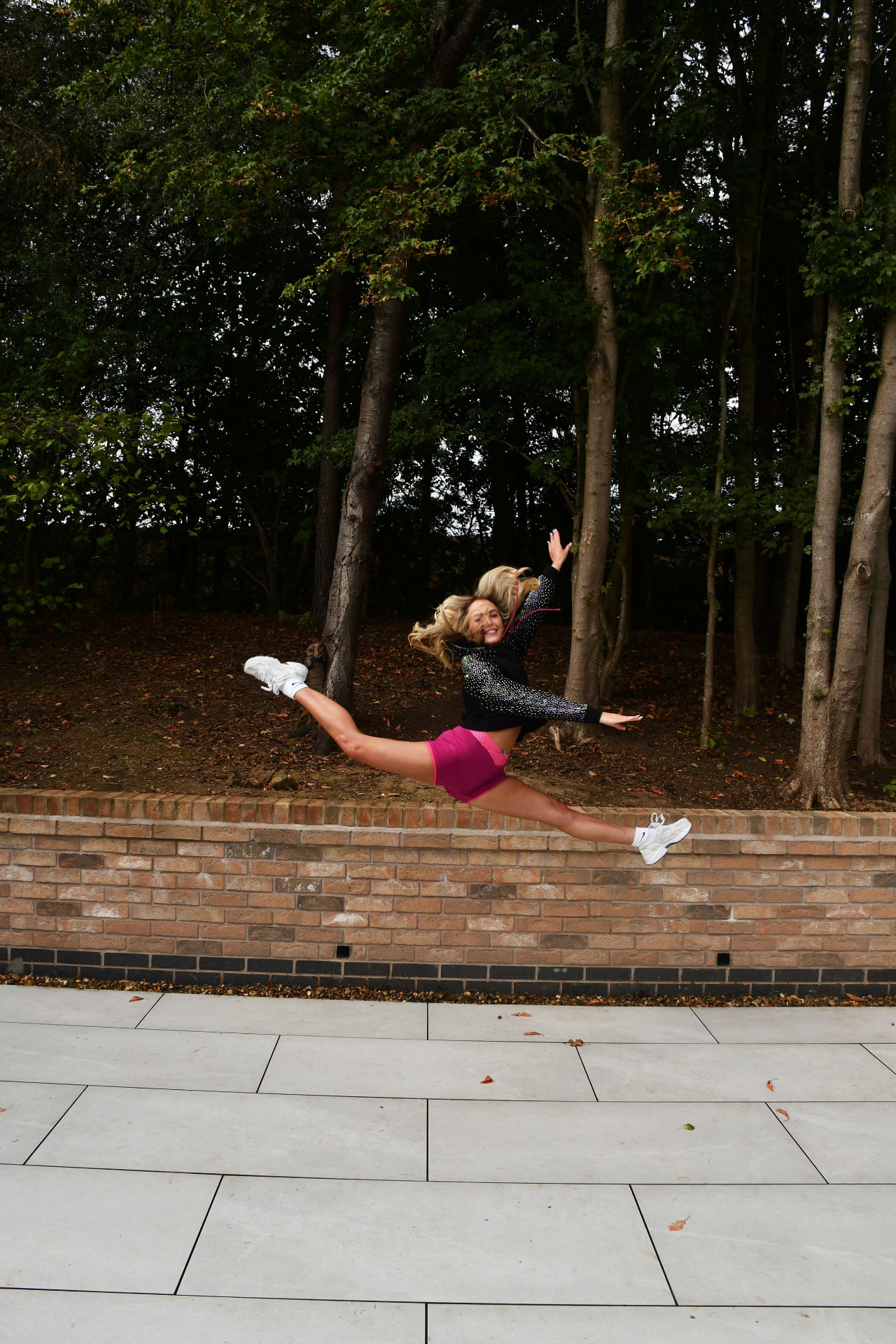 Athlete mid kick outdoors in the Mulberry rhinestone shorts and crop top set